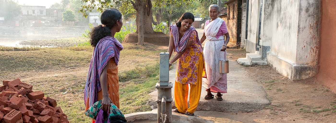 People smiling around a well