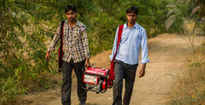 Two men carrying a generator