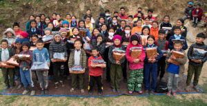 Child Sponsorship Programme - Group of children holding supplies