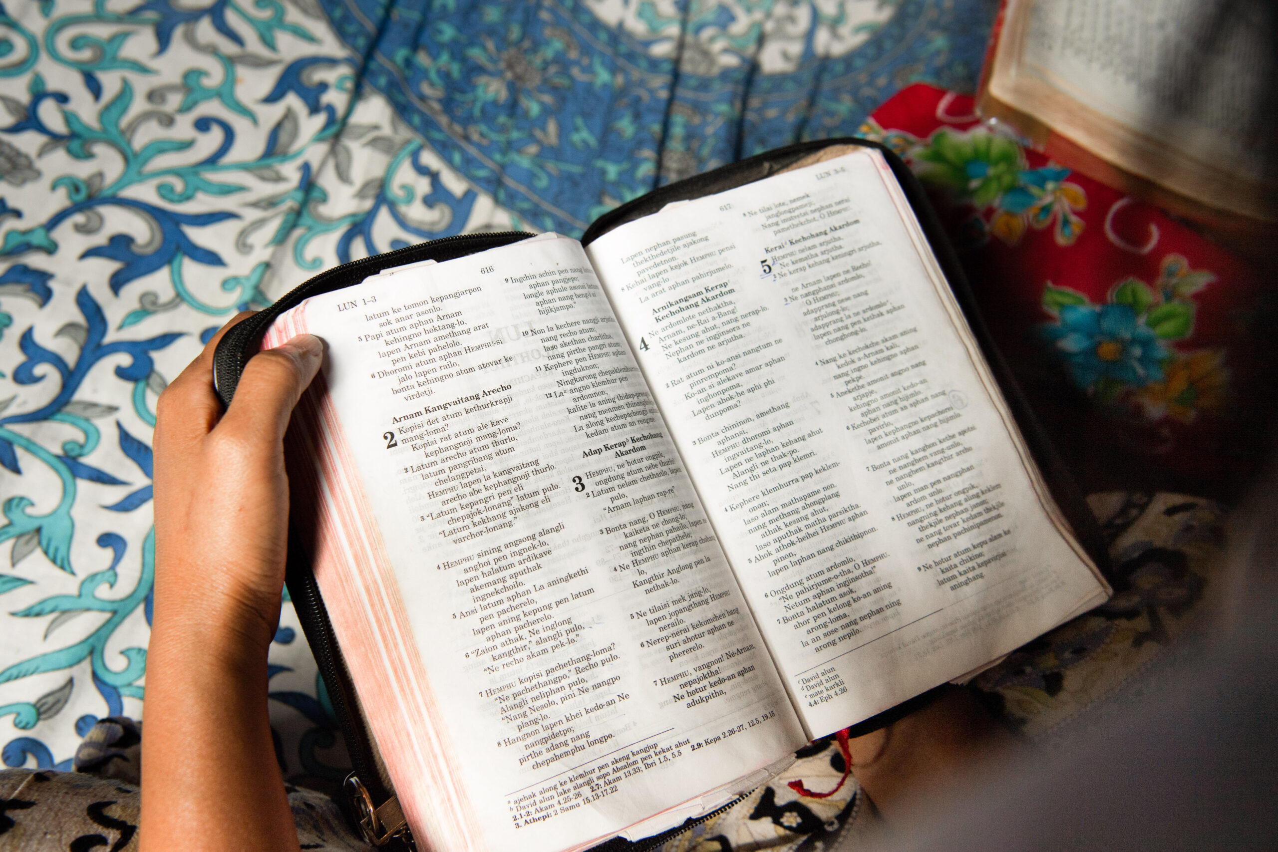 Pray for Bibles and literature: Open bible being read by a missionary