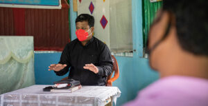 Compassion : Pastor reaching wearing mask